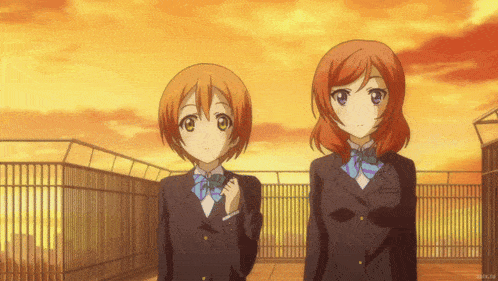 two anime girls are standing next to each other on a balcony with a sunset in the background