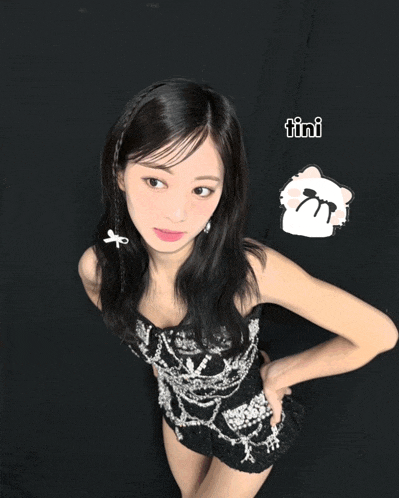 a girl in a black and silver dress with the word tini on the bottom right
