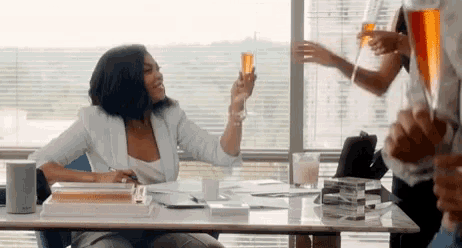 a woman is sitting at a table with a glass of champagne in her hand .