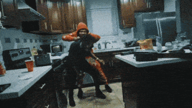 a man in an orange hoodie holds another man on his shoulders