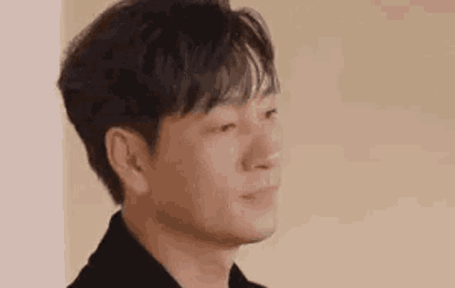a close up of a man 's face with his eyes closed and a smile on his face .