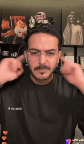 a man wearing glasses and a black shirt that says o to shine on it