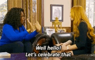 two women are sitting on a couch talking to each other and one of them is saying well hello let 's celebrate that