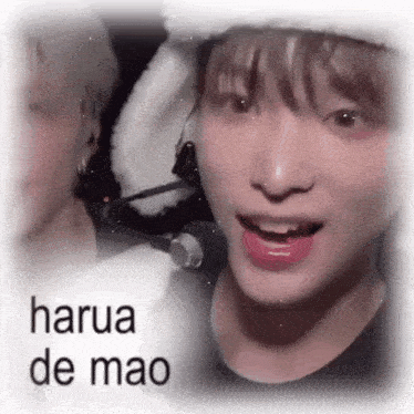 a close up of a person wearing a hat and a microphone with the words `` harua de mao '' written on it .