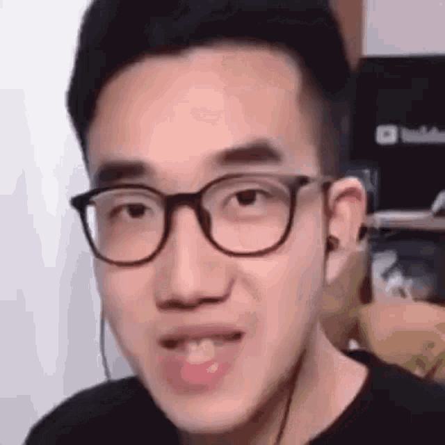 a close up of a man wearing glasses and ear buds .