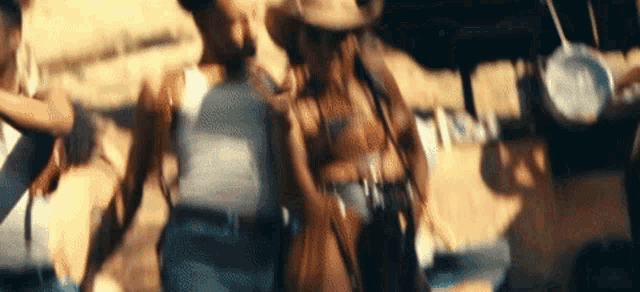a man in a cowboy hat is holding a woman 's hand in a blurry photo .