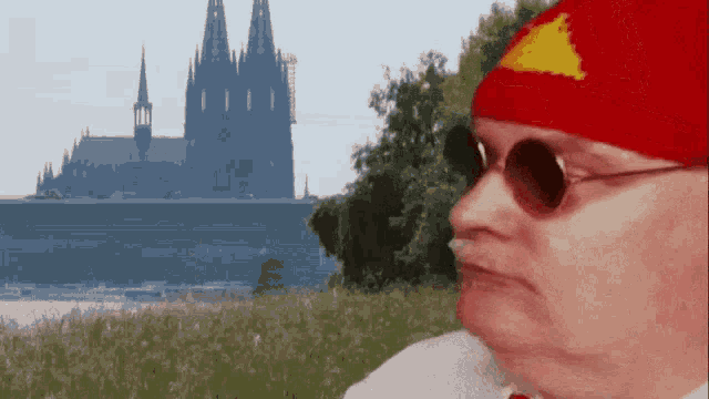 a man wearing sunglasses and a red hat with a yellow triangle on it