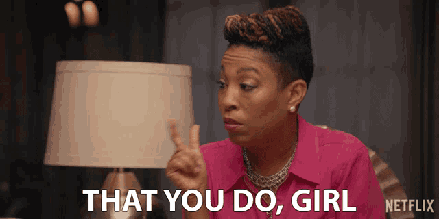 a woman in a pink shirt says that you do girl in front of a lamp
