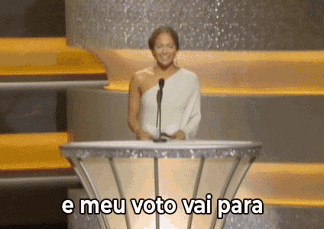 a woman is standing at a podium with the words e meu voto vai para written on the bottom