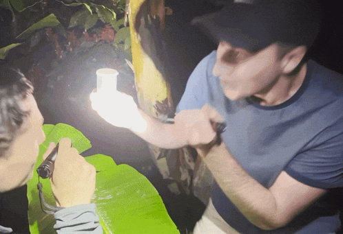 a man in a blue shirt is holding a light bulb