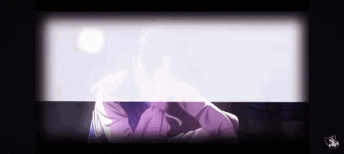 a person in a purple shirt is sitting in front of a white wall .