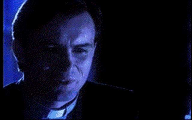 a close up of a man 's face in a dark room