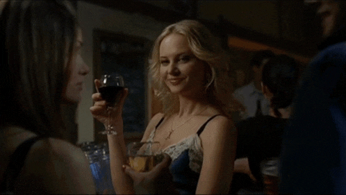 a woman holds a glass of wine in her hand