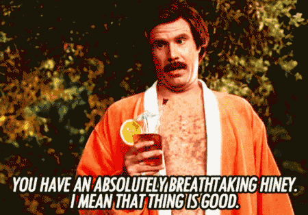 a shirtless man in an orange robe is holding a drink and says " you have an absolutely breathtaking hiney "