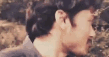 a close up of two men kissing each other in a blurry photo .