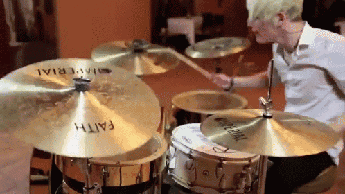 a man is playing drums with a pair of cymbals that say faith