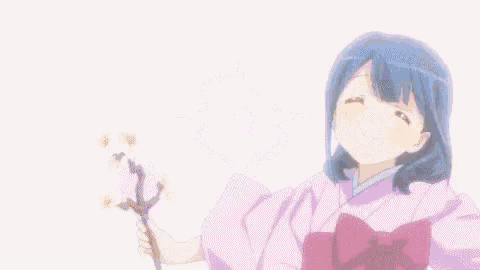 a girl with blue hair and pink ears is holding a pink flower in her hands .