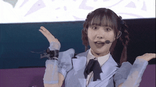 a girl wearing a microphone and a bow tie is making a funny face