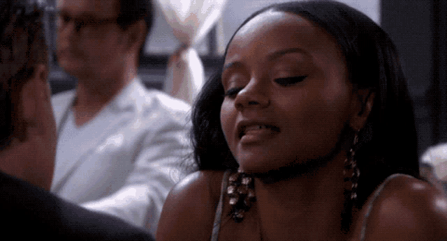 a woman wearing earrings is looking at a man