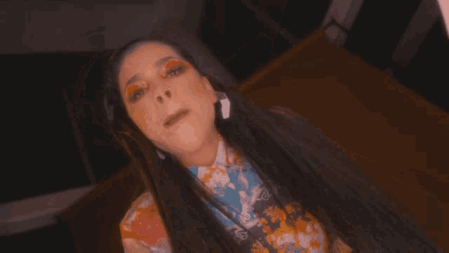 a woman wearing a shirt with a pattern on it is laying down
