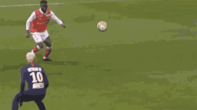 a soccer player wearing a number 10 jersey is kicking a soccer ball