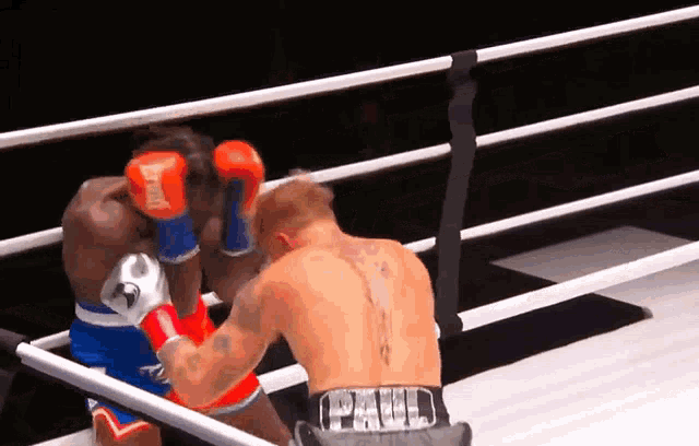 two boxers in a ring one of whom is wearing a paul belt