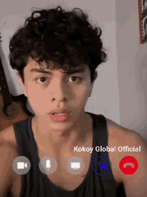 a young man with curly hair is talking on a video call with kokoy global official