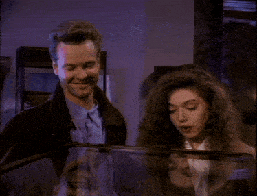 a man and a woman are looking at a display case