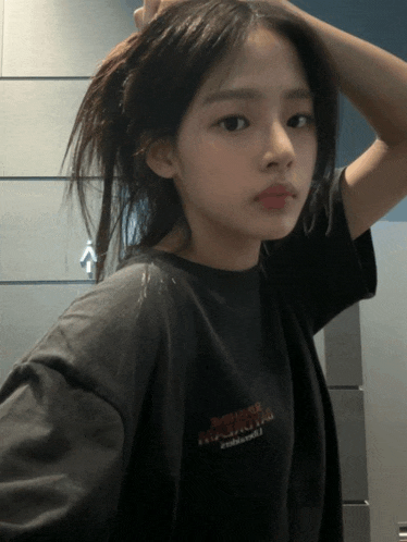 a girl wearing a black t-shirt that says ' nirvana ' on the front