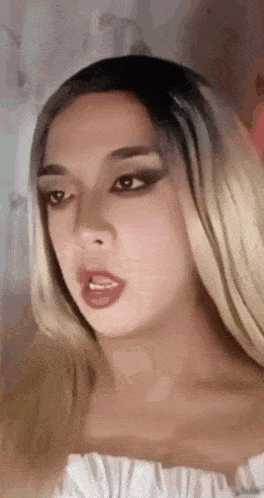 a close up of a woman wearing a wig and making a face .