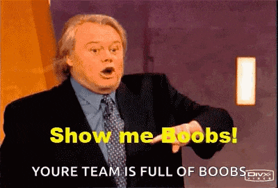 a man in a suit and tie is pointing and saying show me boobs .