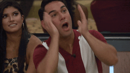 a man in a red and white shirt holds his hands to his face