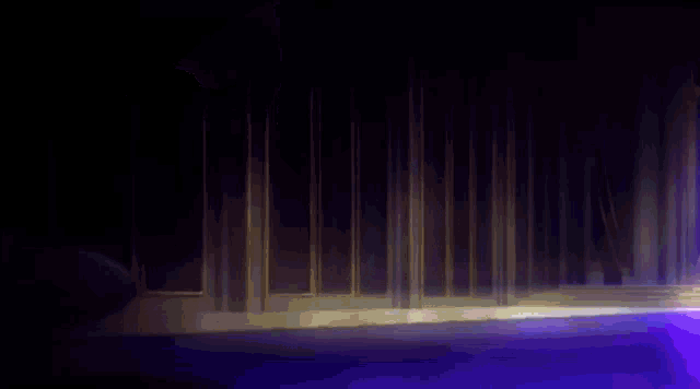 a group of people are dancing on a stage in a dark room with a purple light coming out of the ceiling .