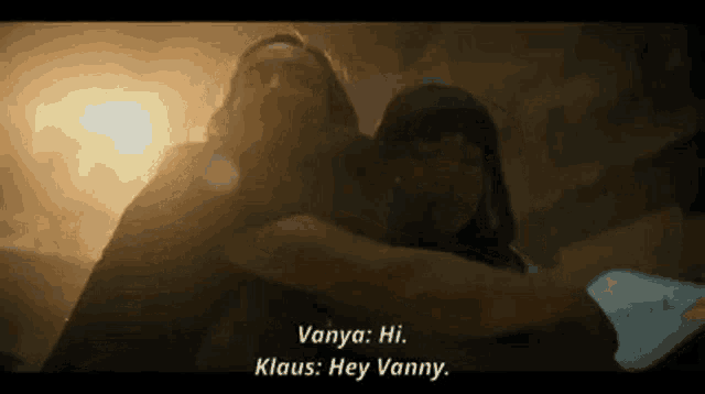 a man and a woman are hugging each other in a dark room and talking to each other .