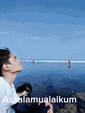 a man looking up at the ocean with the words assalamualaikum written on the bottom