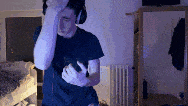 a man wearing headphones is standing in front of a mirror in a bedroom
