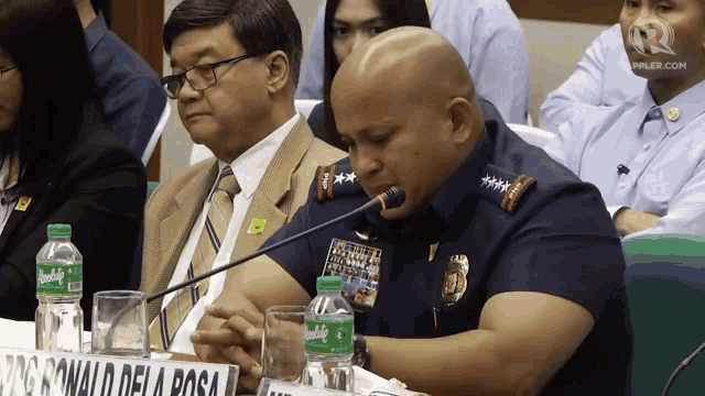 a man speaking into a microphone with a sign that says pagronald dela rosa