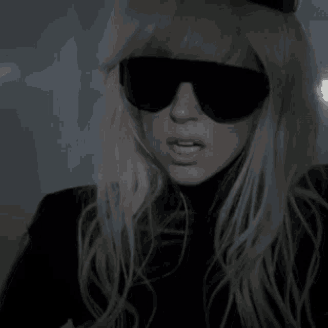a woman with blonde hair wearing sunglasses and a top hat