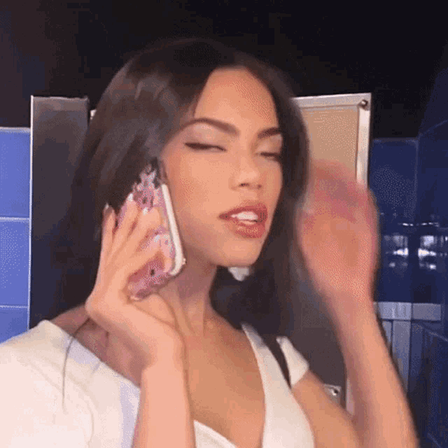 a woman is talking on a cell phone in a public restroom .