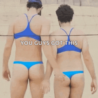 a couple of women in bikinis are walking on a beach .