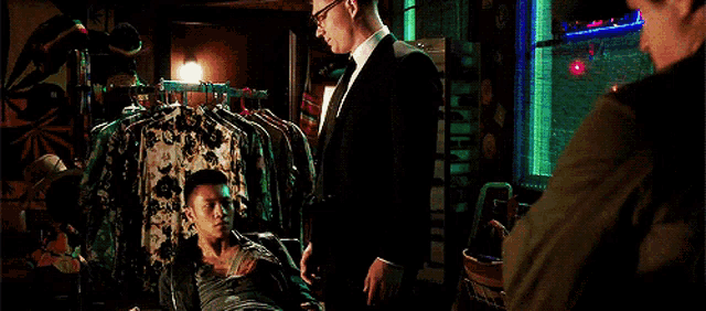 a man in a suit and tie is standing next to another man
