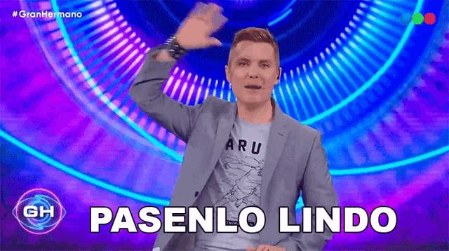 a man in a suit says pasenlo lindo on a screen