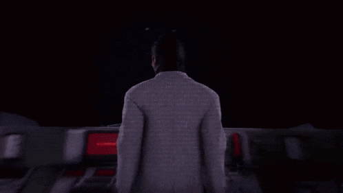 a man in a suit and glasses is standing in the dark