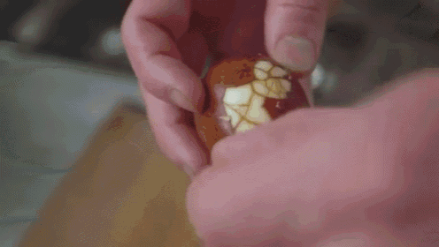 a close up of a person peeling an apple with a knife .