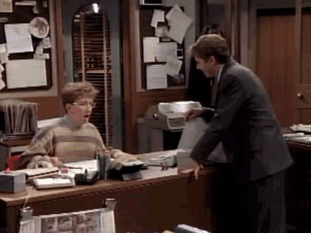 a man in a suit is talking to a boy in a sweater