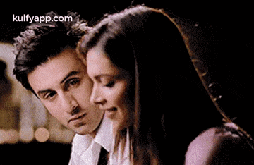 a man and a woman are sitting next to each other and hugging .