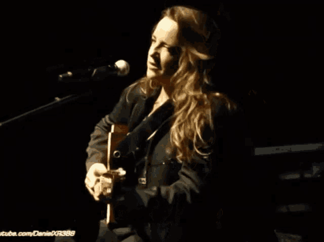 a close up of a woman singing into a microphone with youtube.com written on the bottom