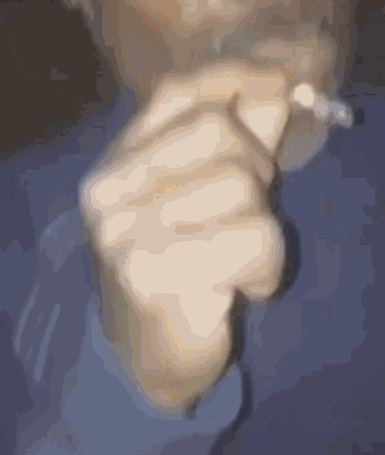a blurry image of a person 's hand with a ring on it