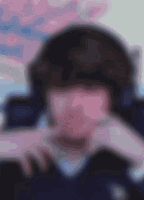 a blurry picture of a person 's face with a pink background