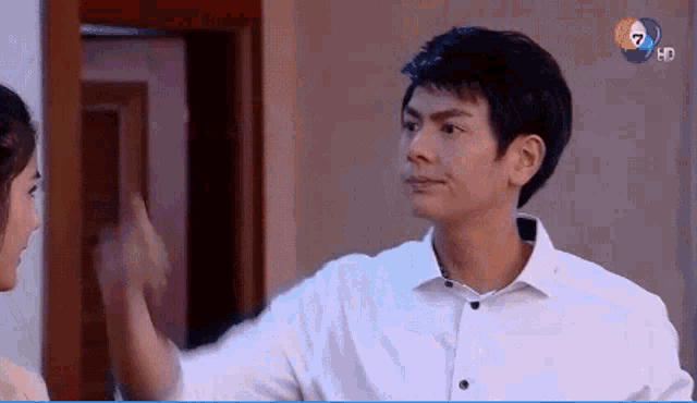 a man in a white shirt is giving a high five to a woman in a pink dress .